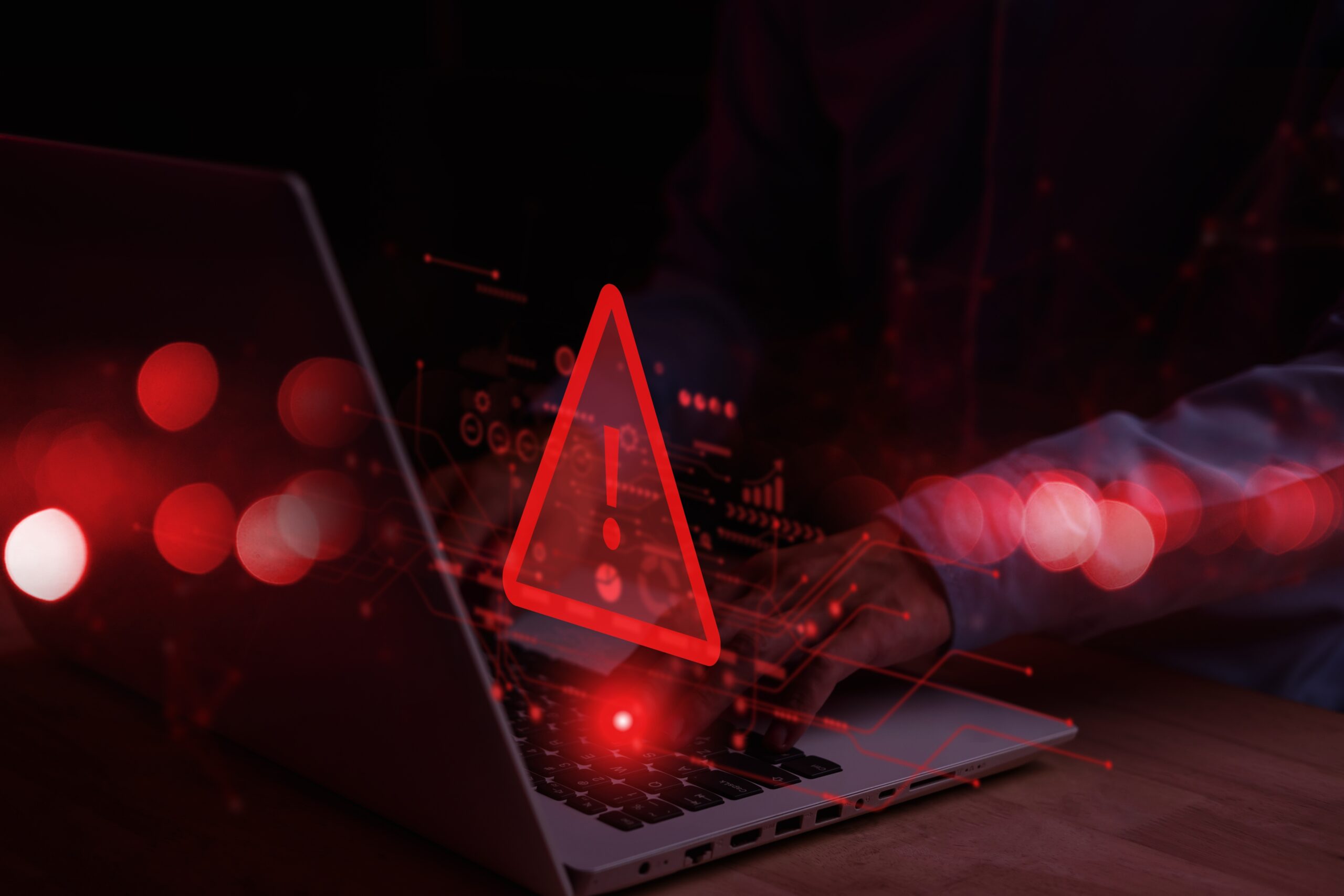 close up of a laptop with a red digital triangle with exclamation over it